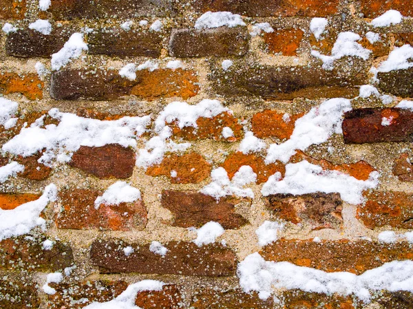 Pared de ladrillo marrón rojo cubierto de copos de nieve —  Fotos de Stock