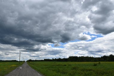 Bulutlu gökyüzü altında bir kır şeridi, Quebec, Kanada