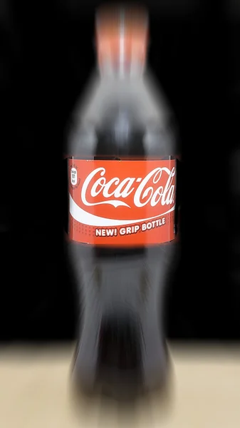 Láhev Coca Cola v rozostření zobrazení — Stock fotografie