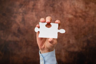 Yapboz 'un iki parçasını tutan eller iş yerinde kayıp fikirleri bulmak ve çözmek için işbirliği yapıyor. İşadamı çözüm için strateji buluyor, düşünceleri birbirine bağlıyor.