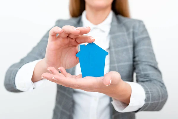 A Lady Holding Home In Business Outfit Presenting Possibility Of Owning Your Own Real Estate. Buying House Or Moving New Insurance Or Mortage Concept Shown By The Young Businesswoman. — 스톡 사진