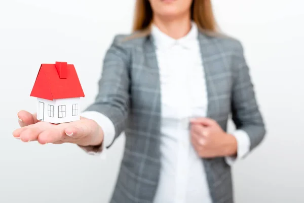 A Lady Holding Home In Business Outfit Presenting Possibility Of Owning Your Own Real Estate. Buying House Or Moving New Insurance Or Mortage Concept Shown By The Young Businesswoman. — Foto de Stock