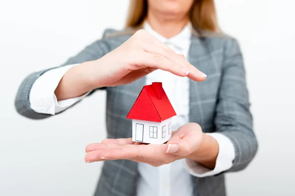 A Lady Holding Home In Business Outfit Presenting Possibility Of Owning Your Own Real Estate. Buying House Or Moving New Insurance Or Mortage Concept Shown By The Young Businesswoman. — 스톡 사진