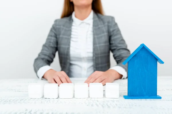 A Lady Holding Home In Business Outfit Presenting Possibility Of Owning Your Own Real Estate. Buying House Or Moving New Insurance Or Mortage Concept Shown By The Young Businesswoman. — 스톡 사진
