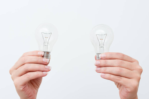 Woman Hands Holding Lamp Presenting Ideas For Project, Man Palm Showing Bulbs And New Technologies, Two Held Lightbulbs Exhibiting Another Opinion