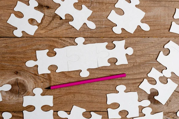 Close-Up White Jigsaw Pattern Puzzle Pieces To Be Connected With Missing Last Piece Positioniert auf einem flachen Hintergrund mit unterschiedlicher Textur und Papierzubehör Zubehör — Stockfoto