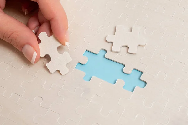 Крупный план Белый Jigsaw шаблон головоломки части, которые будут связаны с отсутствием последней части, расположенной на плоском фоновом режиме с различными текстурами и бумагой аксессуары — стоковое фото