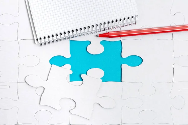 Close-Up White Jigsaw Pattern Puzzle Piezas que se conectarán con faltante última pieza colocada en un fondo plano con diferentes accesorios de textura y papel —  Fotos de Stock