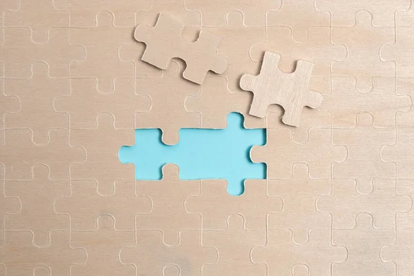 Close-Up White Jigsaw Pattern Puzzle Piezas que se conectarán con faltante última pieza colocada en un fondo plano con diferentes accesorios de textura y papel —  Fotos de Stock