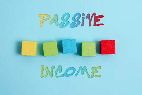 Text sign showing Passive Income. Conceptual photo earnings extracted from rental property, and other enterprises Stack of Sample Cube Rectangular Boxes On Surface Polished With Multi-Colour