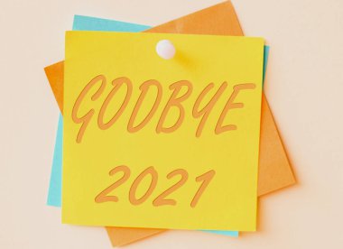 Kavramsal başlık Godbye 2021 iş konsepti geçen yılın sonunda ya da ayrılırken iyi dileklerini iletir Renkli Kağıt Notlar bir arada tutulur ve duvara asılır.