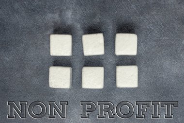 İlham veren Non Profit metni. İş dünyası, kar amacı gütmeyen ya da yürütülmeyen bir etkinlik sergileyerek Yüzeyde Çoklu Renklerle Parlatılmış Küp Dikdörtgen Kutular