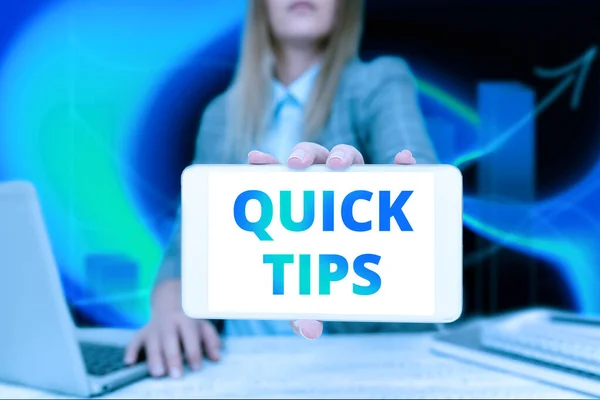 Концептуальный заголовок Quick Tips. Концепция, означающая небольшой, но особенно полезный практический совет Деловая женщина, сидящая в офисе, держит мобильный дисплей футуристических идей. — стоковое фото