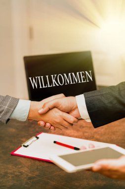 Başlık Willkommen 'i temsil ediyor. İş dünyasına hoş geldin etkinliği ya da evinizi iki profesyonel iyi giyimli iş adamının el sıkışması gibi bir şey.