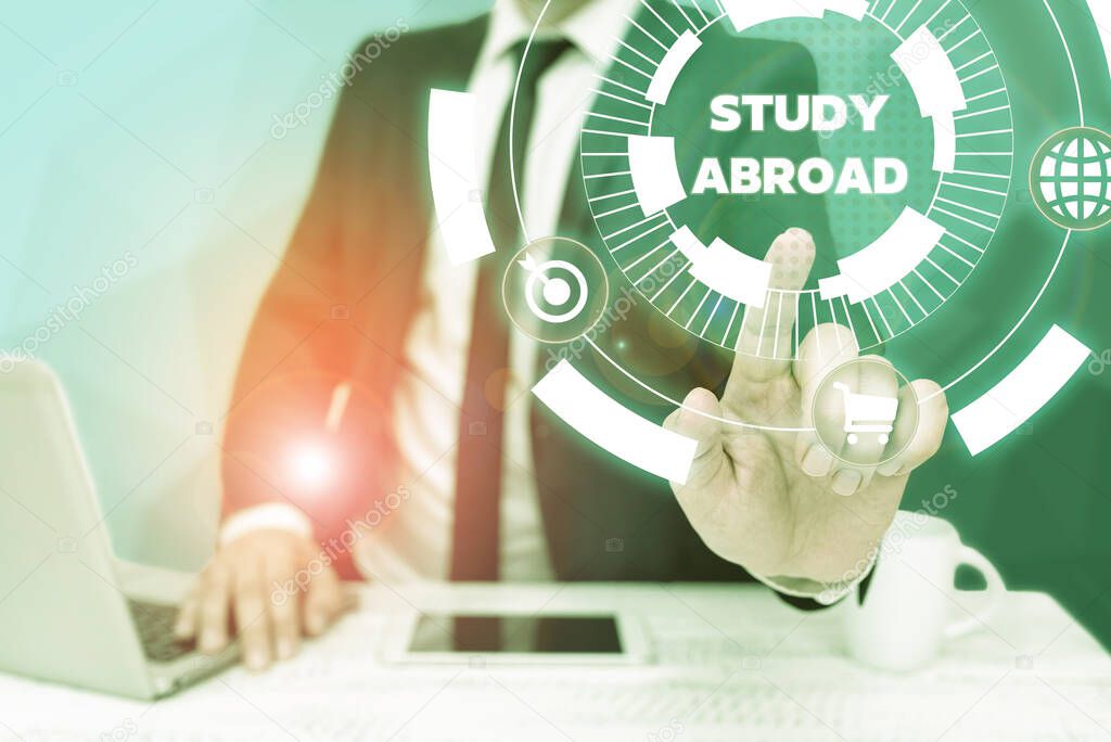 Text showing inspiration Study Abroad. Word for Pursuing educational opportunities in a foreign country Bussiness Man Sitting Desk Laptop And Phone Pointing Futuristic Technology.
