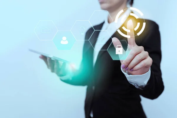 Vrouw in pak Side Standing Holding Tablet terwijl het verhogen van de vinger Toont Futuristische Interface. Lady in uniform dragen van mobiele telefoon wijzend op moderne grafische weergave. — Stockfoto