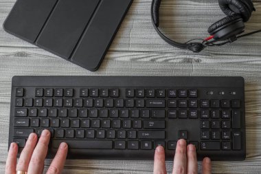 Eller Bilgisayar Klavyesine Basarak Kulaklık Tableti ile Yeni Fikirler Yazıyor. Taze Düşünceler Yazan Parmaklar Kablosuz Not Defteri ile Tazeleniyor.