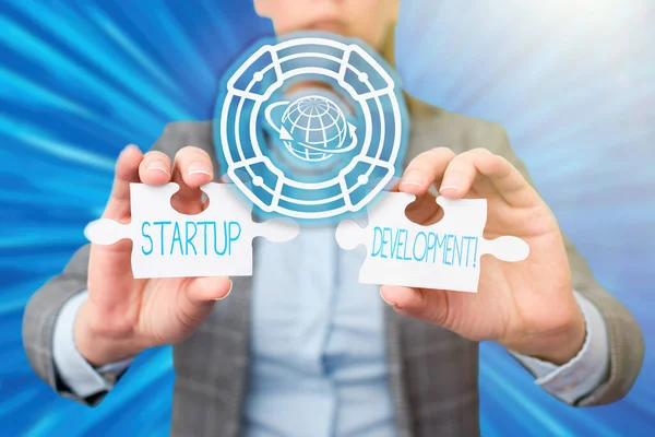 Text sign showing Startup Development. Internet Concept efficiently develop and validate scalable business model Business Woman Holding Jigsaw Puzzle Piece Unlocking New Futuristic Tech. — Photo