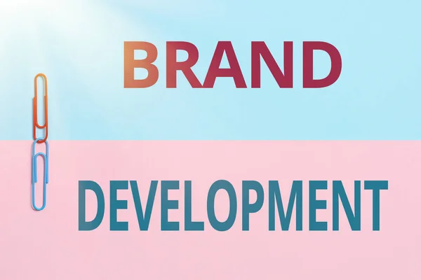 Text showing inspiration Brand Development. Business overview improving customers knowledge and opinions of a brand Two Objects Arranged Facing Inward Outward On a Separated Coloured Background