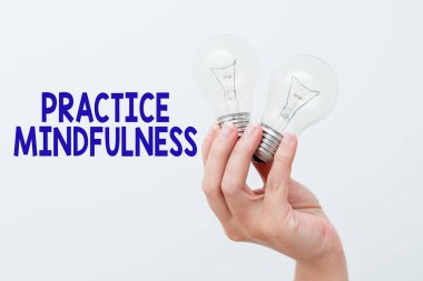 Uygulama farkındalığını gösteren metin işareti. İş görüşü, yargılamadan sansasyonlara dikkat etmek. El, elinde iki lamba tutarak yeni teknoloji fikirleri sunmak ya da göstermek.