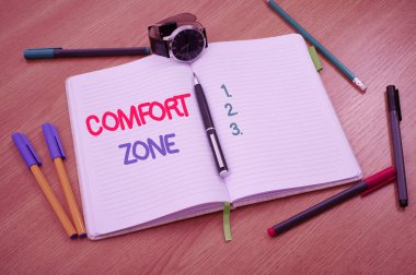 Metin Konfor Bölgesi gösterimi yazılıyor. İş vitrini. Kendini güvende ya da rahat hissettiğin bir durum. Boş Not Defteri Kol Saati Etrafı dağınık kırtasiye malzemeleriyle çevrili..