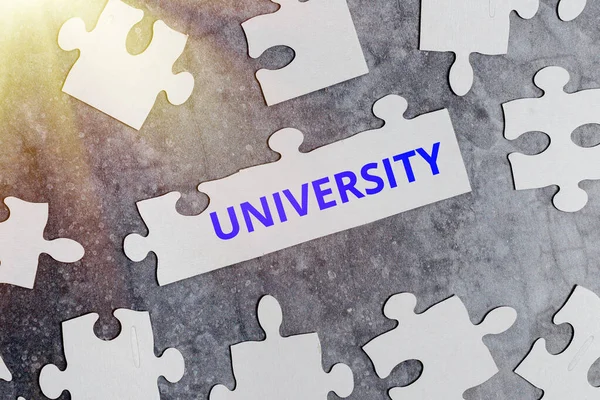 Hand writing sign University. Concept meaning an educational institution designed to teach and investigate Building An Unfinished White Jigsaw Pattern Puzzle With Missing Last Piece — 스톡 사진