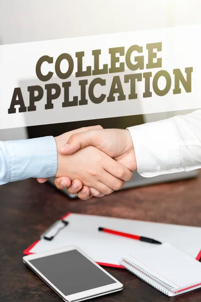Sign displaying College Application. Concept meaning individuals apply to gain entry into a college Two Professional Well-Dressed Corporate Businessmen Handshake Indoors