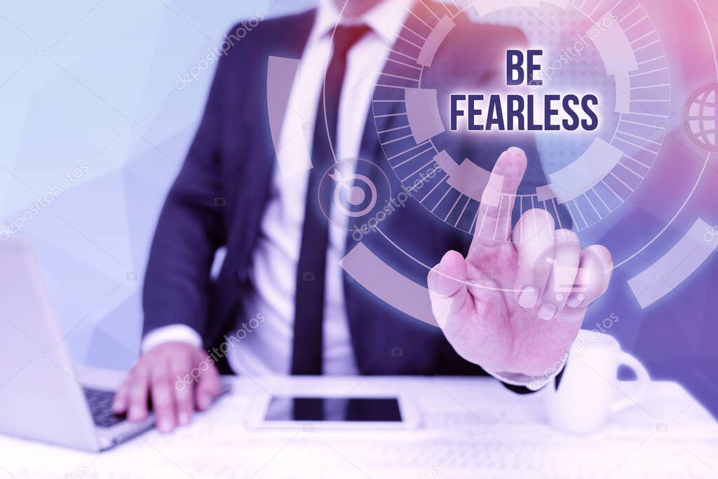 Hand writing sign Be Fearless. Internet Concept act of striving to lead an extraordinary life and make a difference Bussiness Man Sitting Desk Laptop And Phone Pointing Futuristic Technology.