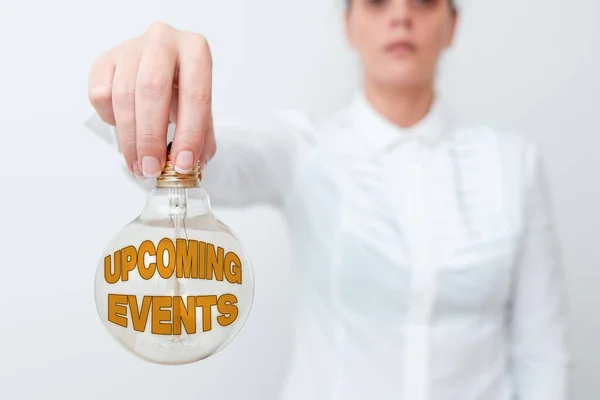 Conceptual caption Upcoming Events. Conceptual photo the approaching planned public or social occasions Lady in outfit holding lamp upside down presenting new technology ideas — Stockfoto