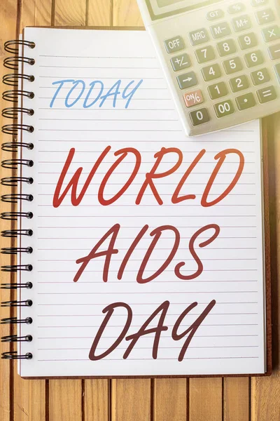 Text caption presenting World Aids Day. Business concept an international day to raised awareness of the AIDS pandemic Blank Open Spiral Notebook With A Calculator Placed On Table. — Stockfoto