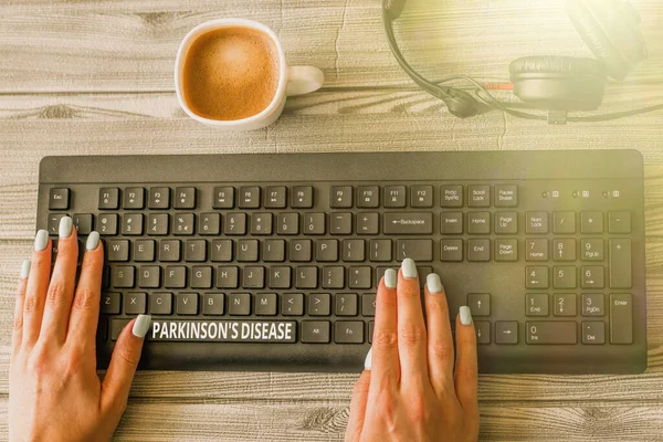 Texto que mostra inspiração Parkinson S Is Disease. Visão geral do negócio distúrbio do sistema nervoso que afeta o movimento Teclado sobre uma mesa ao lado de uma taça de cerâmica preenchida com cerveja quente. — Fotografia de Stock