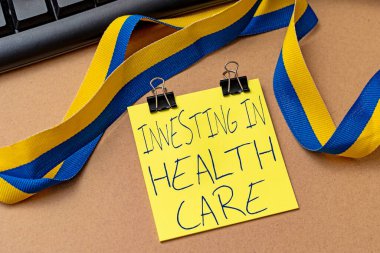 Sağlık Hizmetleri Yatırımını gösteren bir tabela. İnternet Konsepti, sağlığın bakımı veya iyileştirilmesi üzerine para yatırdı. Çeşitli Koleksiyon Ofisi Kırtasiyesi Fotoğrafı Tablo Üzerine yerleştirildi