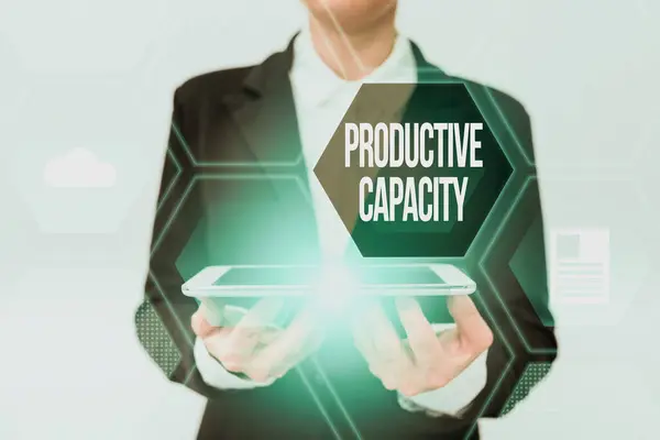 Sign displaying Productive Capacity. Concept meaning the maximum possible output of a production plant Lady In Uniform Holding Phone And Showing Futuristic Virtual Display — Stock Photo, Image