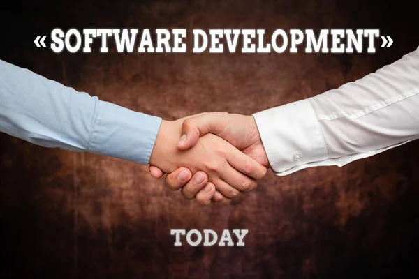 Hand writing sign Software Development. Internet Concept software is created using a specific programming Two Professional Well-Dressed Corporate Businessmen Handshake Indoors