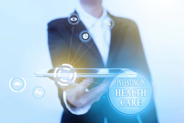 Inspiration showing sign Investing In Health Care. Business overview put money on maintenance or improvement of health Lady In Suit Presenting Mobile Device With Futuristic Interface Tech.