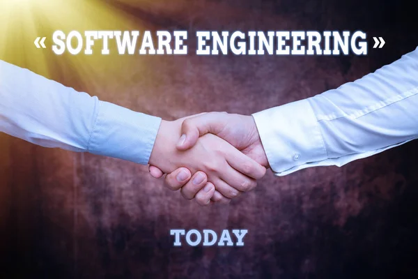 Hand writing sign Software Engineering. Internet Concept apply engineering to the development of software Two Professional Well-Dressed Corporate Businessmen Handshake Indoors