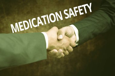 Text showing inspiration Medication Safety. Concept meaning freedom from preventable harm with medication use Two Professional Well-Dressed Corporate Businessmen Handshake Indoors