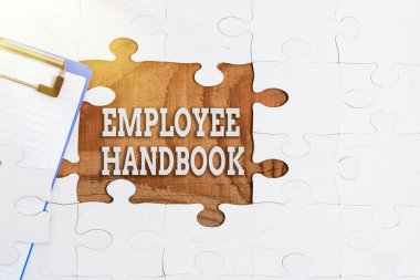 Conceptual caption Employee Handbook. Word for states the rules and regulations and policies of a company Building An Unfinished White Jigsaw Pattern Puzzle With Missing Last Piece