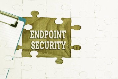 Handwriting text Endpoint Security. Internet Concept the methodology of protecting the corporate network Building An Unfinished White Jigsaw Pattern Puzzle With Missing Last Piece