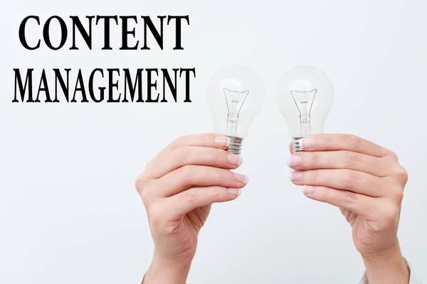 Bildunterschrift: Content Management. Business-Übersichtsprogramme zur Erstellung und Verwaltung digitaler Inhalte mit zwei Händen, die eine Lampe halten, die neue technologische Ideen zeigt oder präsentiert — Stockfoto