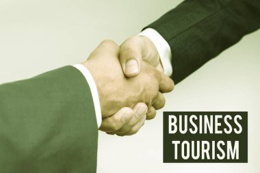 İş Turizmini gösteren bir tabela. Bir şirketten ayrılma fikri, iki profesyonel iyi giyimli iş adamının kapalı mekanda el sıkışmasıdır.