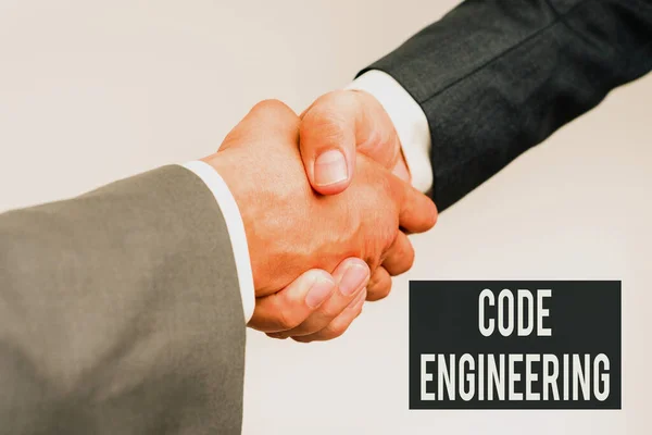 Writing displaying text Code Engineering. Business overview application of engineering to the development of software Two Professional Well-Dressed Corporate Businessmen Handshake Indoors
