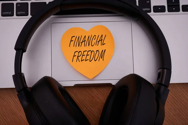 A Pénzügyi Szabadságot bemutató szövegfelirat. Koncepció jelentése, hogy nagy döntéseket anélkül, hogy hangsúlyozta a pénz üres jegyzettömb Laptop tollal és fejhallgatóval mellett csésze meleg kávé. — Stock Fotó