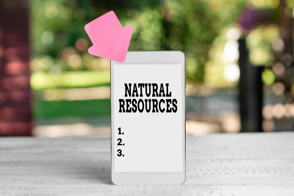 Рукописний знак "Природні ресурси". Матеріали бізнес-ідеї, які зустрічаються в природі і використовуються для економічної вигоди Анотація Відкритий смартфон Фотографія, Відображення нового пристрою — стокове фото