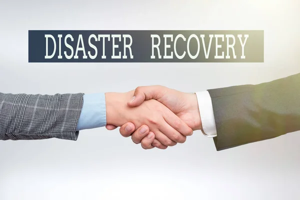 Hand writing sign Disaster Recovery. Business showcase helping showing affected by a serious damaging event Two Professional Well-Dressed Corporate Businessmen Handshake Indoors — Stock Photo, Image