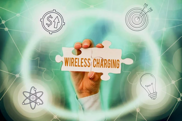 Konzeptionelle Bildunterschrift: Wireless Charging. Geschäftskonzept Methoden zum Laden von Batterien ohne die Verwendung von Kabeln Hand Holding Puzzleteil Erschließung neuer futuristischer Technologien. — Stockfoto
