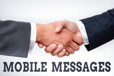 El yazısı işareti Mobil Mesajlar. Elektronik mesajlar yazma ve gönderme eylemi iki profesyonel iyi giyimli iş adamı kapalı mekanda el sıkışıyor.