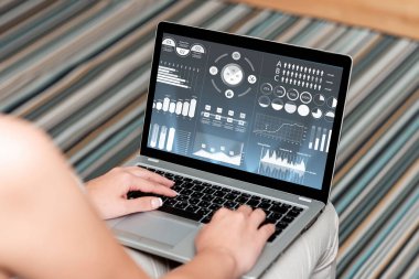 Dizüstü bilgisayarı olan bir kadın evden işe yarayan bir görünüm sergiliyor. Kız Temiz Geniş Ev 'de Uzak Görev Projelerini Tamamlamakla Meşgul.