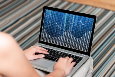 Dizüstü bilgisayarı olan bir kadın evden işe yarayan bir görünüm sergiliyor. Kız Temiz Geniş Ev 'de Uzak Görev Projelerini Tamamlamakla Meşgul.