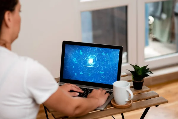 Femme faisant son travail sur un ordinateur portable à côté de belle plante et tasse à café de travail de la maison. Fille faisant des projets à côté de la coupe et la finition de fleurs projets d'emploi à distance. — Photo